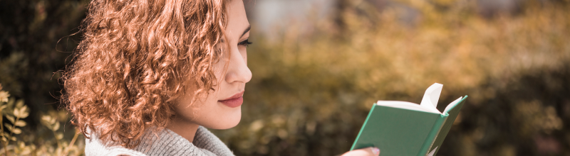žena si čte knihu v parku